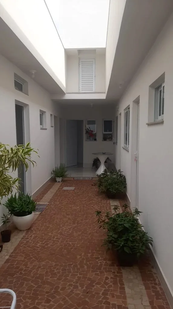 Jardim interno com plantas e piso de pedra portuguesa